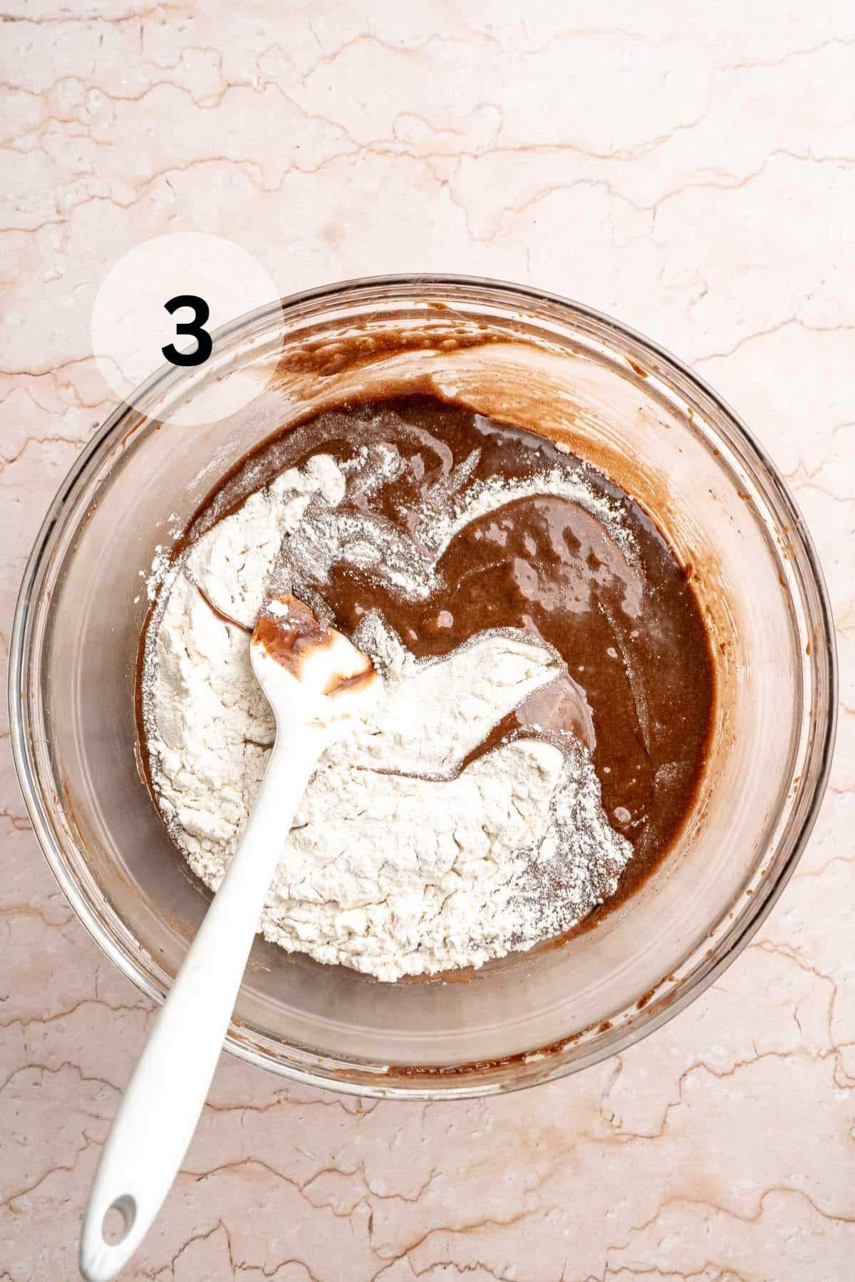 Stirring flour into brownie batter.