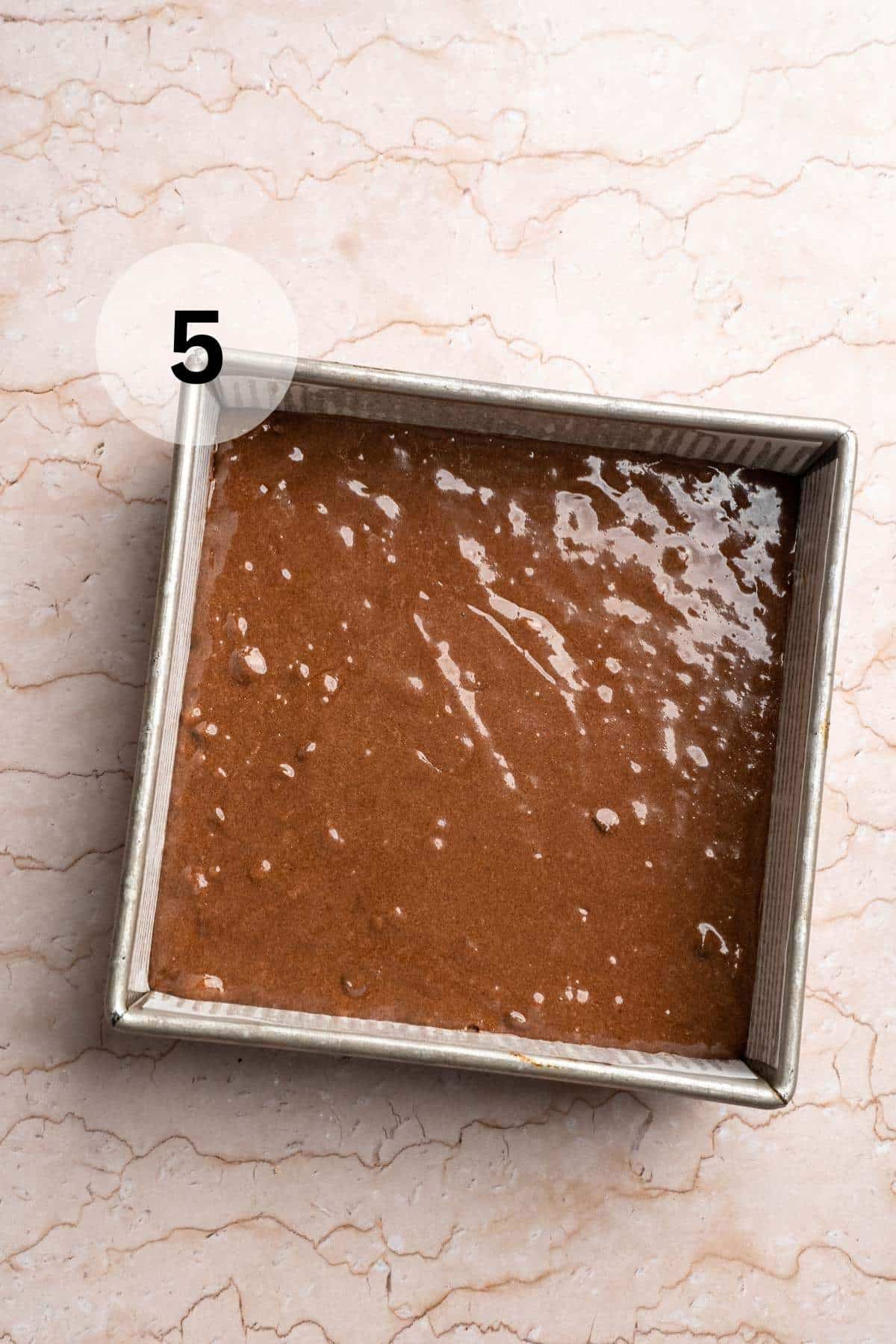 Brownie batter in a square baking pan.