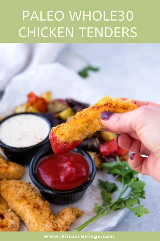 woman's hand dipping chicken tender into ketchup