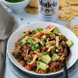 chili topped with diced avocado and tortilla strips and served with beer