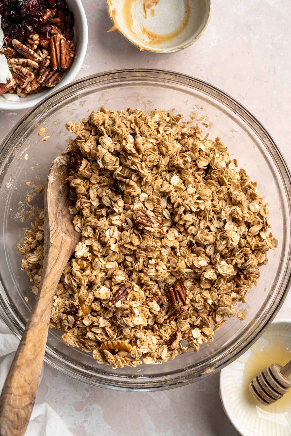 Stirring granola mixture in a large bowl.