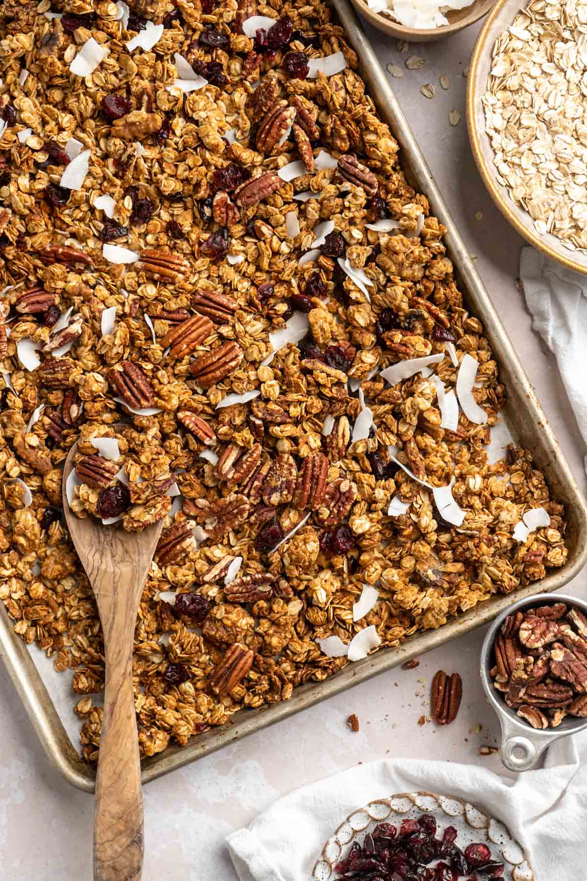 Stirring mix-ins into protein granola on a sheet pan.
