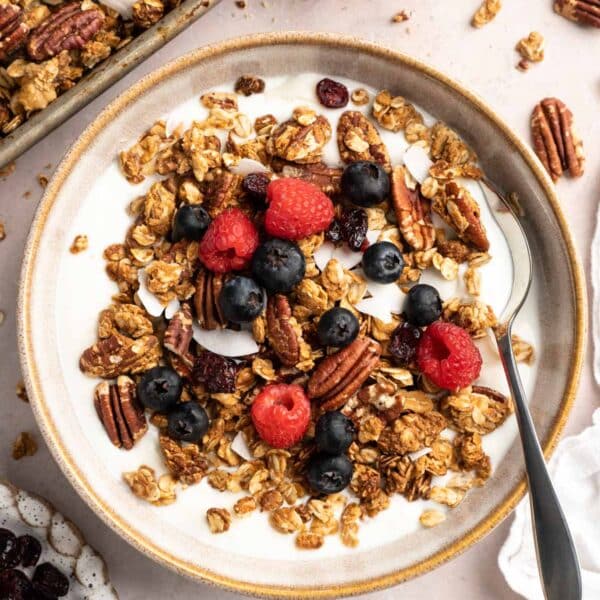 Bowl of milk with protein granola and berries.