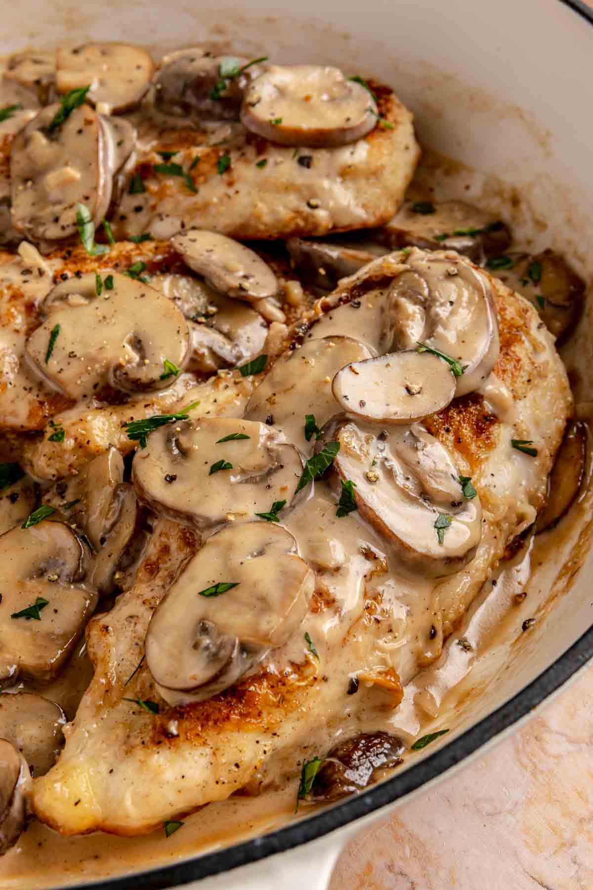 Chicken Marsala in a skillet garnished with fresh parsley.