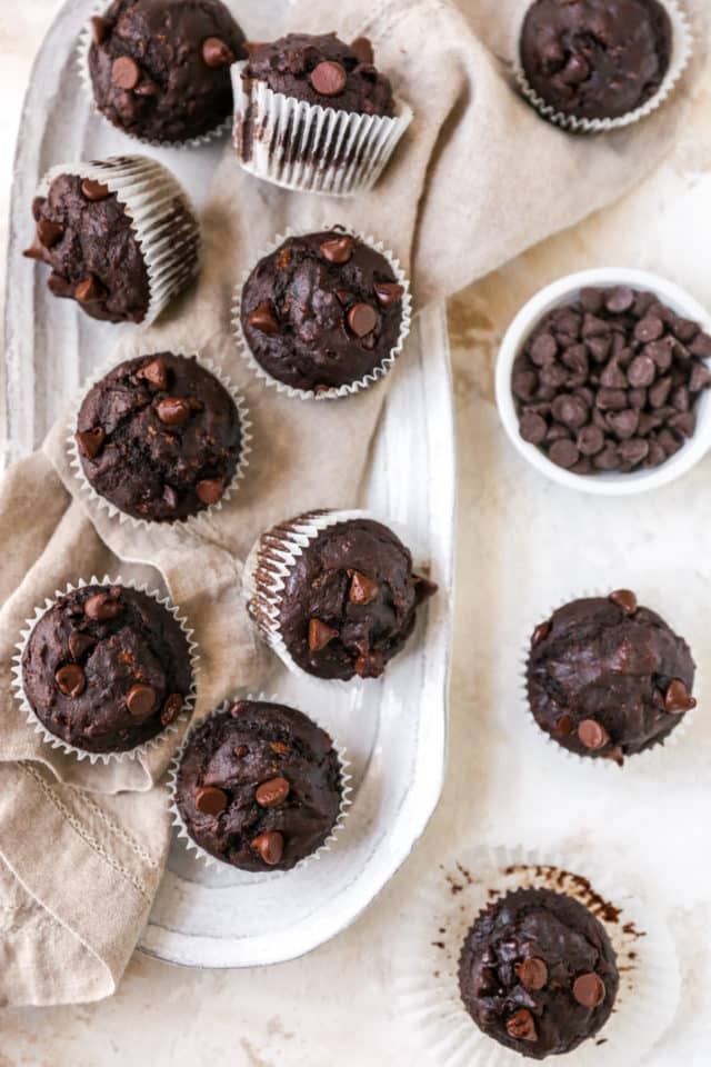 double chocolate banana muffins near a bowl filled with chocolate chips 
