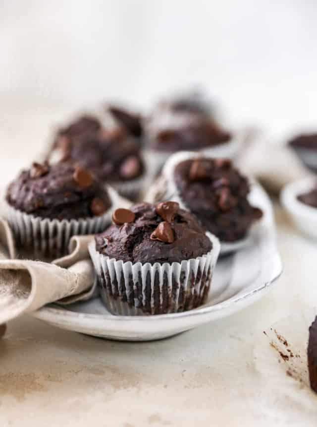 chocolate muffin topped with chocolate chips on a white serving tray
