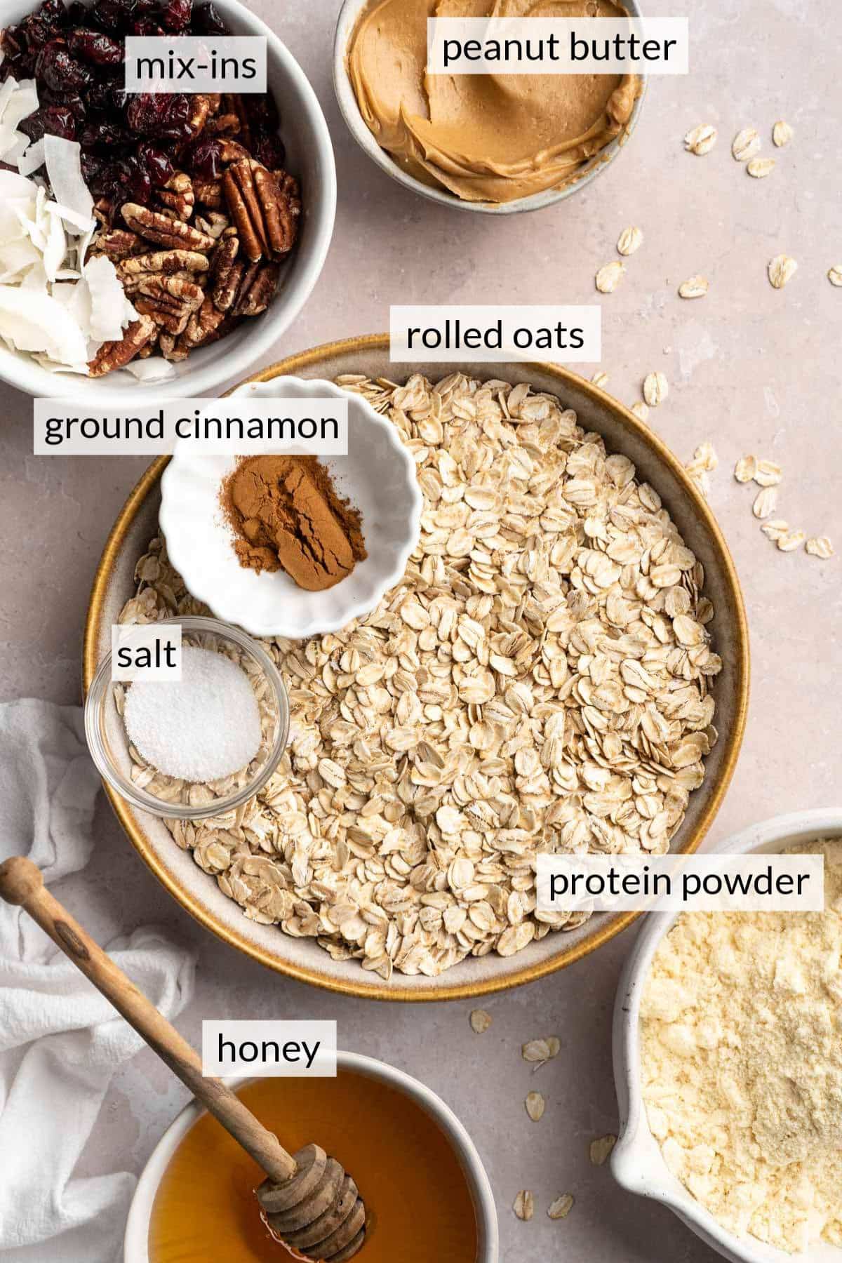 Bowls with rolled oats, ground cinnamon, nuts, peanut butter and honey.