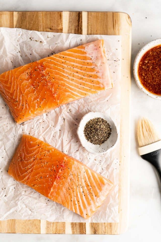 raw salmon fillets on parchment paper