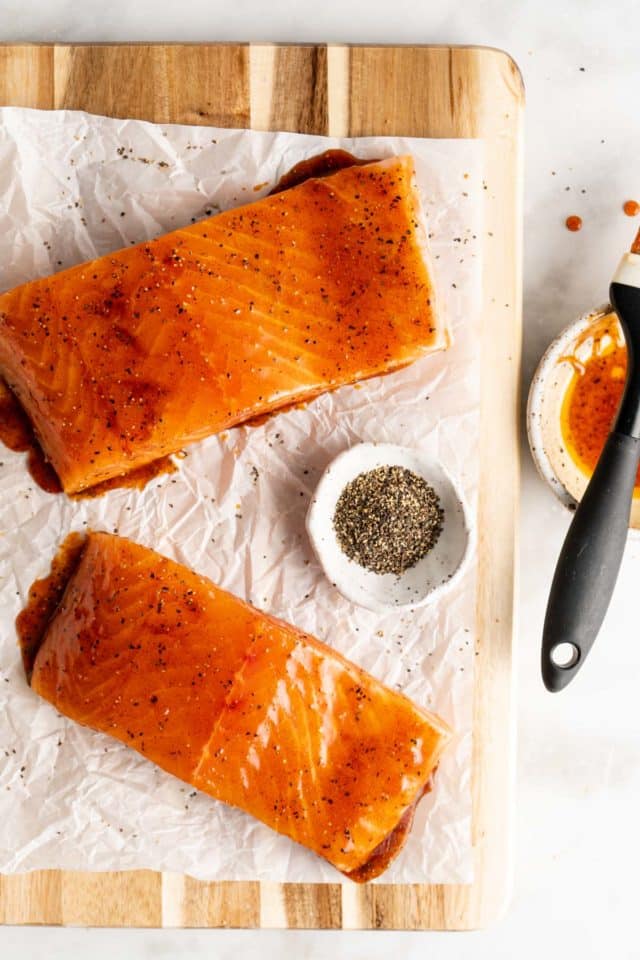 salmon fillets on parchment paper covered in a honey glaze