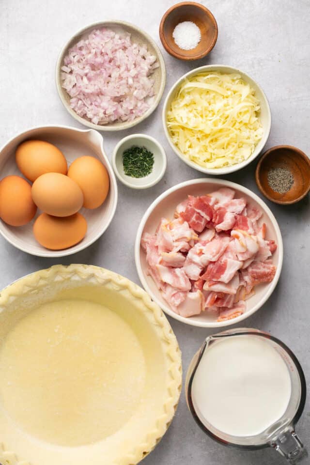 Ingredients for making quiche divided into small bowls.