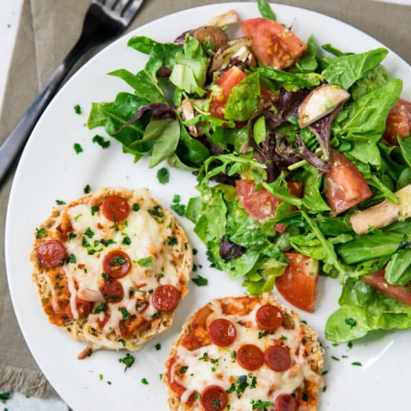Mini Pepperoni Pizzas on a white plate with a side salad