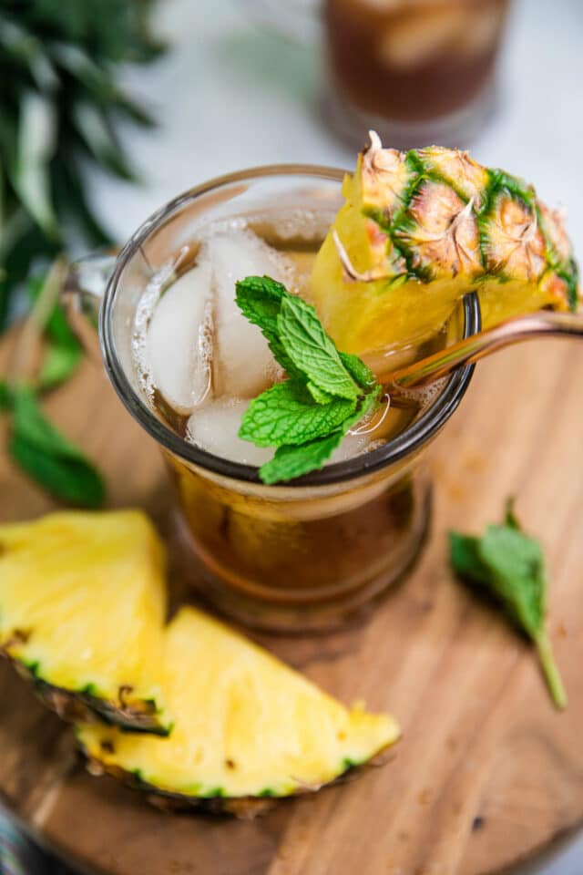 glass of iced tea with sprigs of mint and pineapple chunks