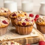 Raspberry oat muffins topped with oats and served with milk.