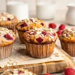Raspberry oat muffins topped with oats and served with milk.