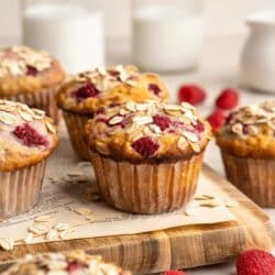 Raspberry oat muffins topped with oats and served with milk.