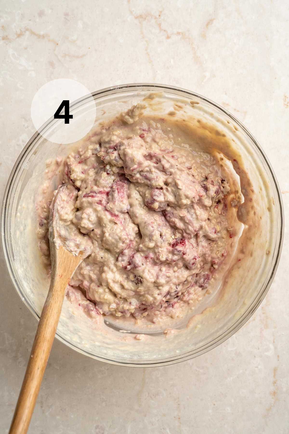 Using a wooden spoon to stir together muffin batter.
