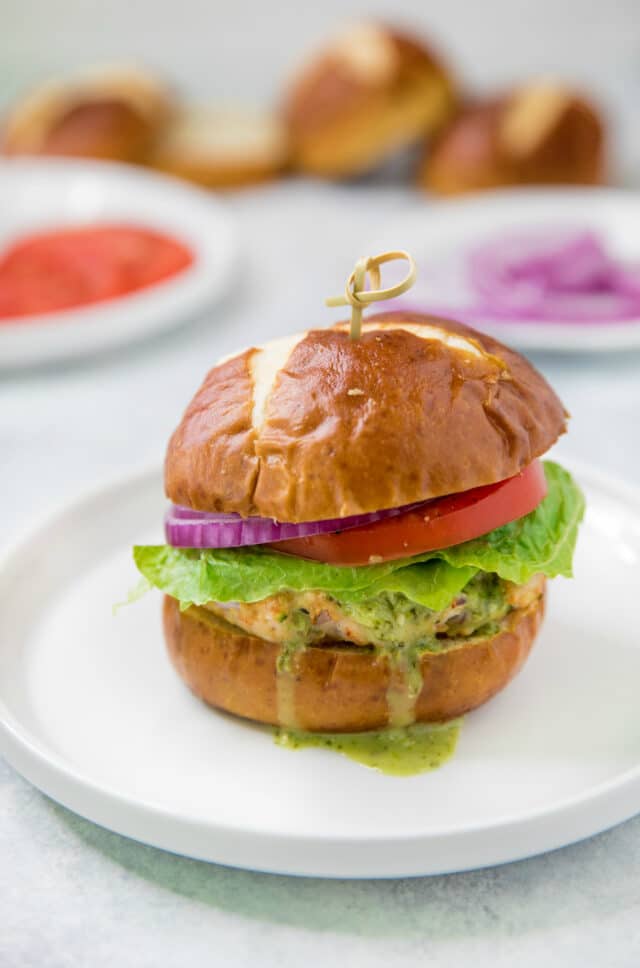 turkey burger with a pretzel bun topped with lettuce, tomato, red onion 