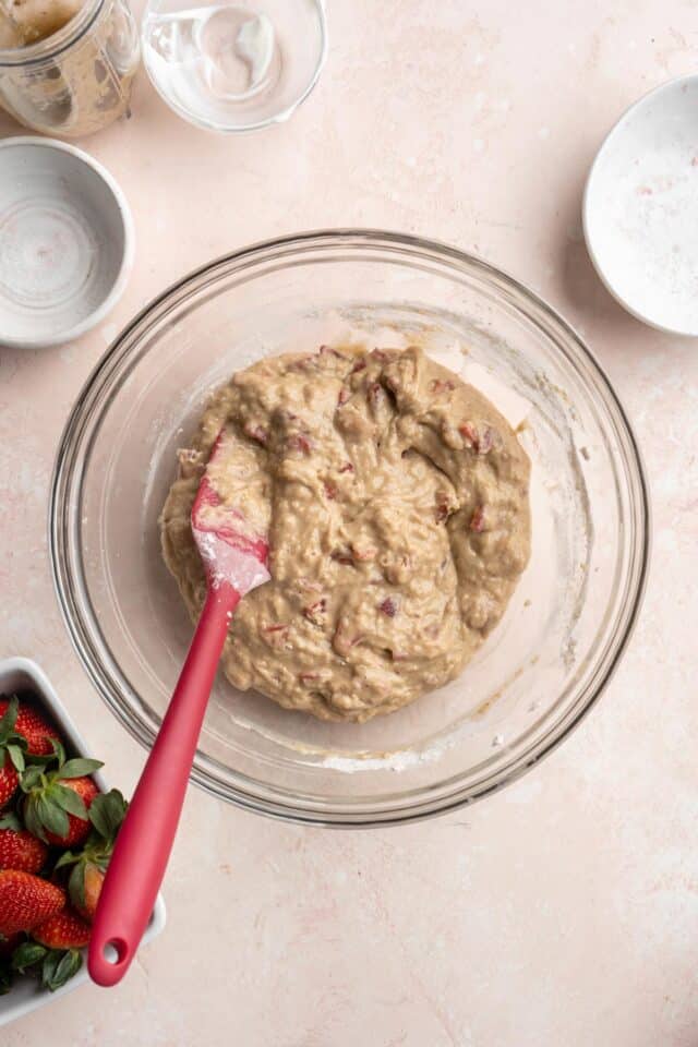 Stirring flour mixture into wet ingredients with a spatula.