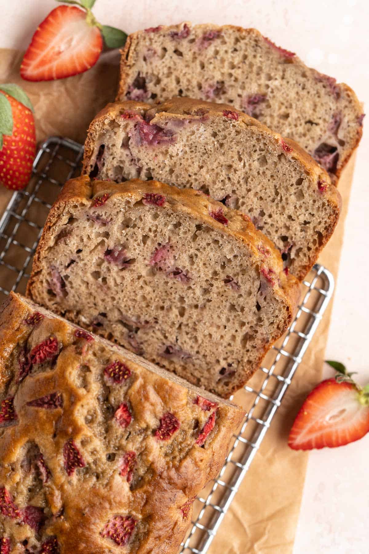 Sliced strawberry banana bread on a wire rack.