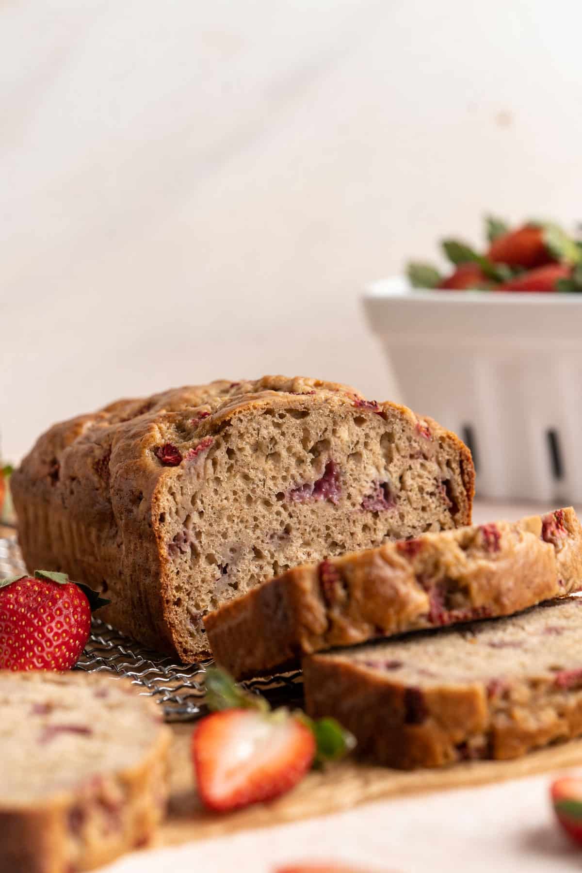 A loaf of partially sliced strawberry banana bread.