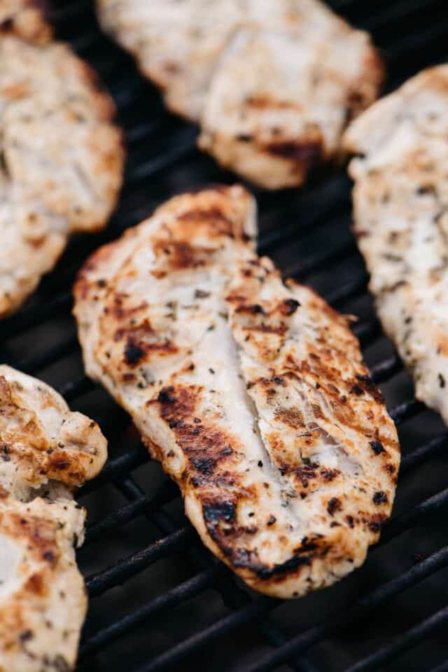 thin chicken breasts cooking on a grill