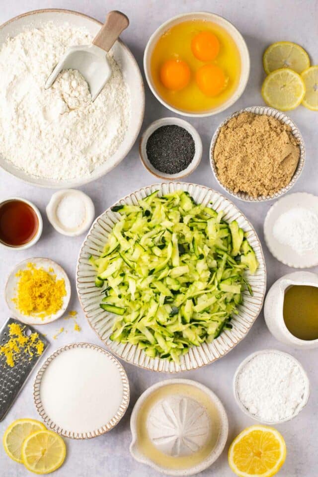 Shredded zucchini and other ingredients divided into small bowls.
