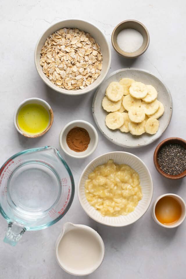 Oats, mashed banana and other ingredients divided into small bowls.