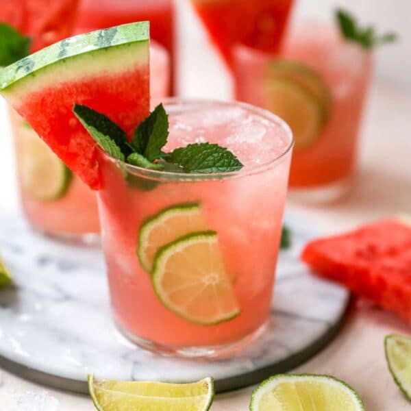 Watermelon cocktail garnished with a watermelon wedge, mint and lime.