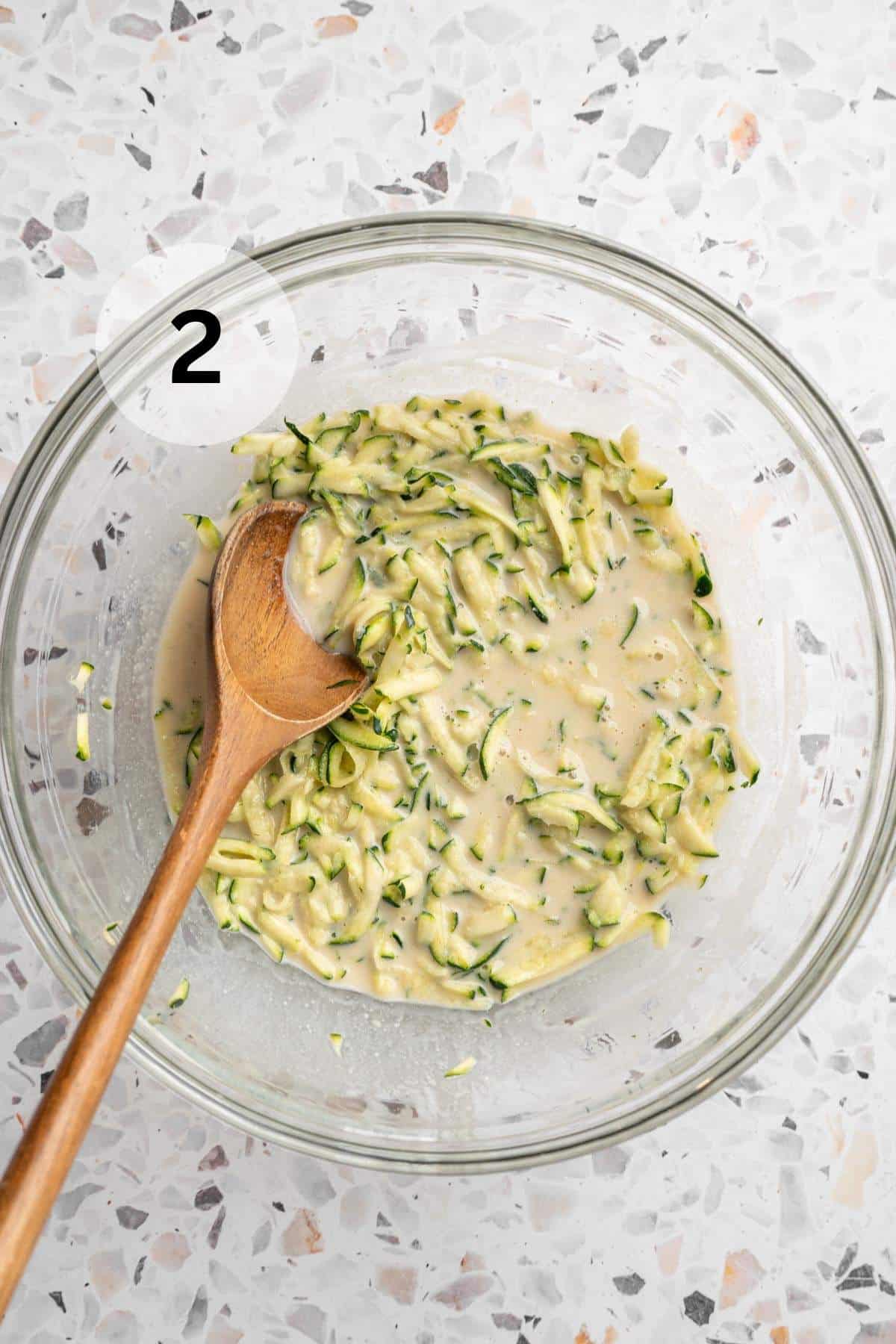 Stirring together zucchini with milk, coconut oil, egg and vanilla.
