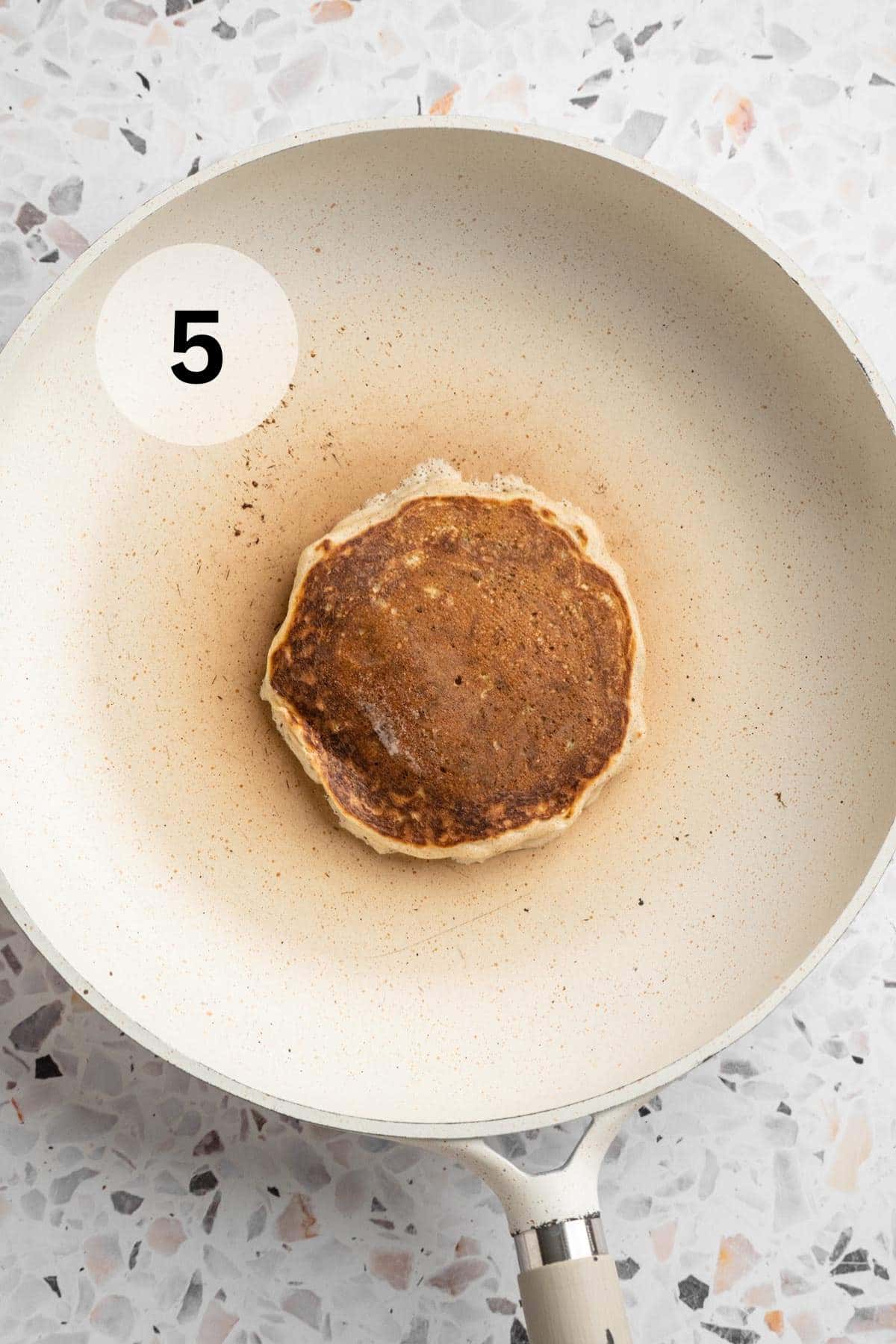 Pancake cooking in a skillet.