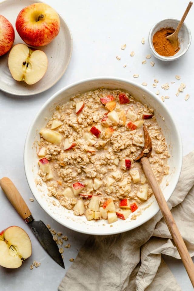 stirring together oatmeal with milk and chopped apple