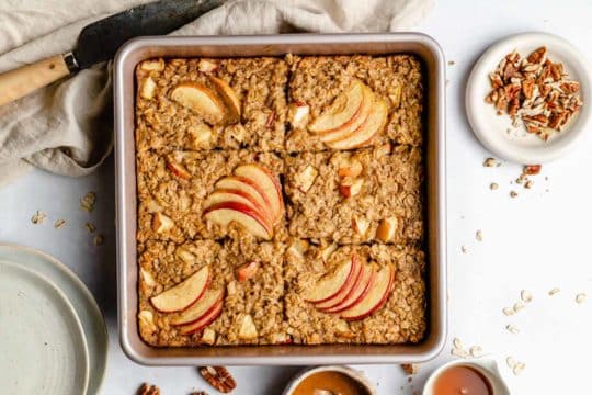 baked oatmeal topped with apple slices in a baking dish
