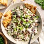 Honey mustard chicken salad in a bowl with pita chips and a spoon.
