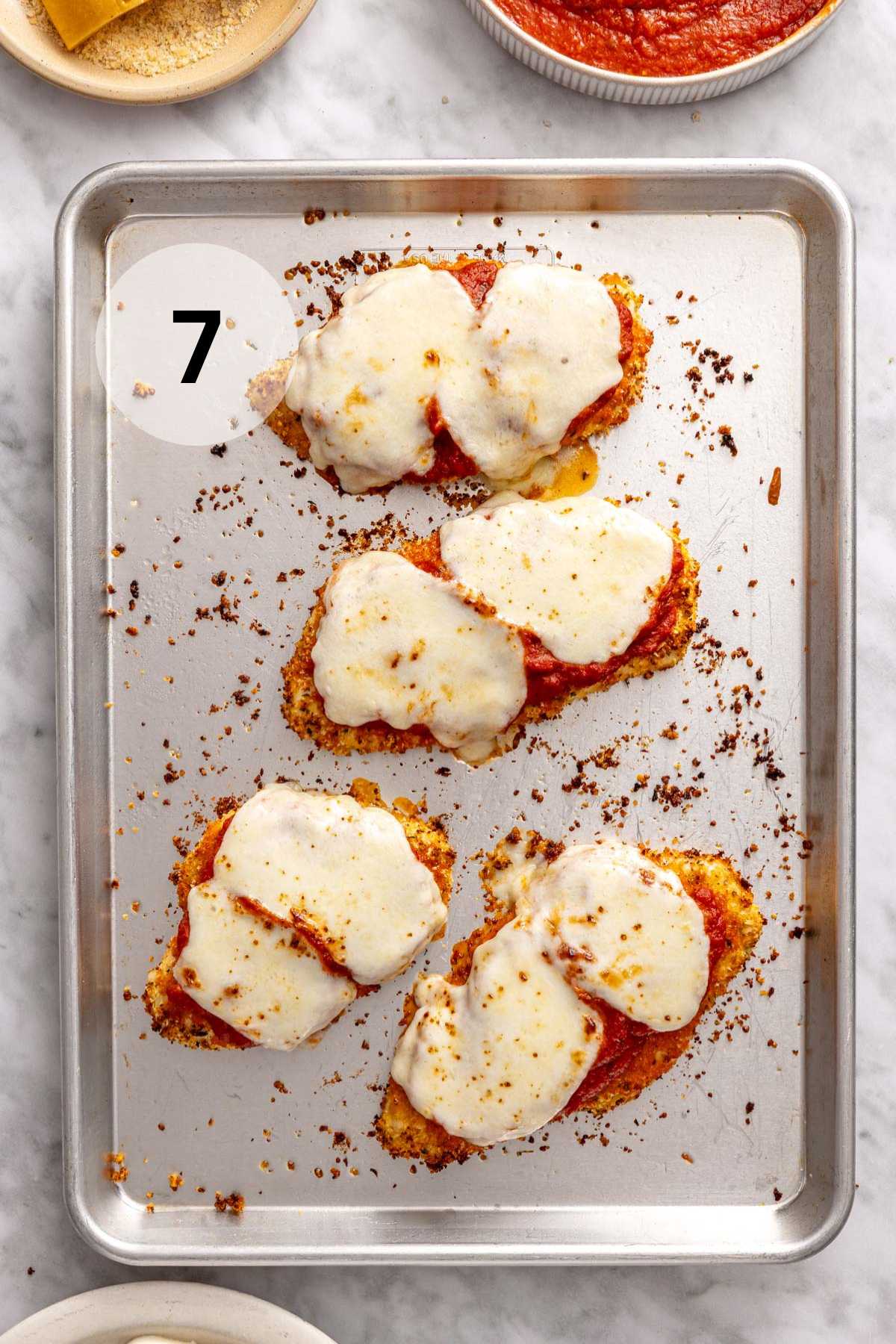 Melted cheese and marinara on top of chicken breasts.
