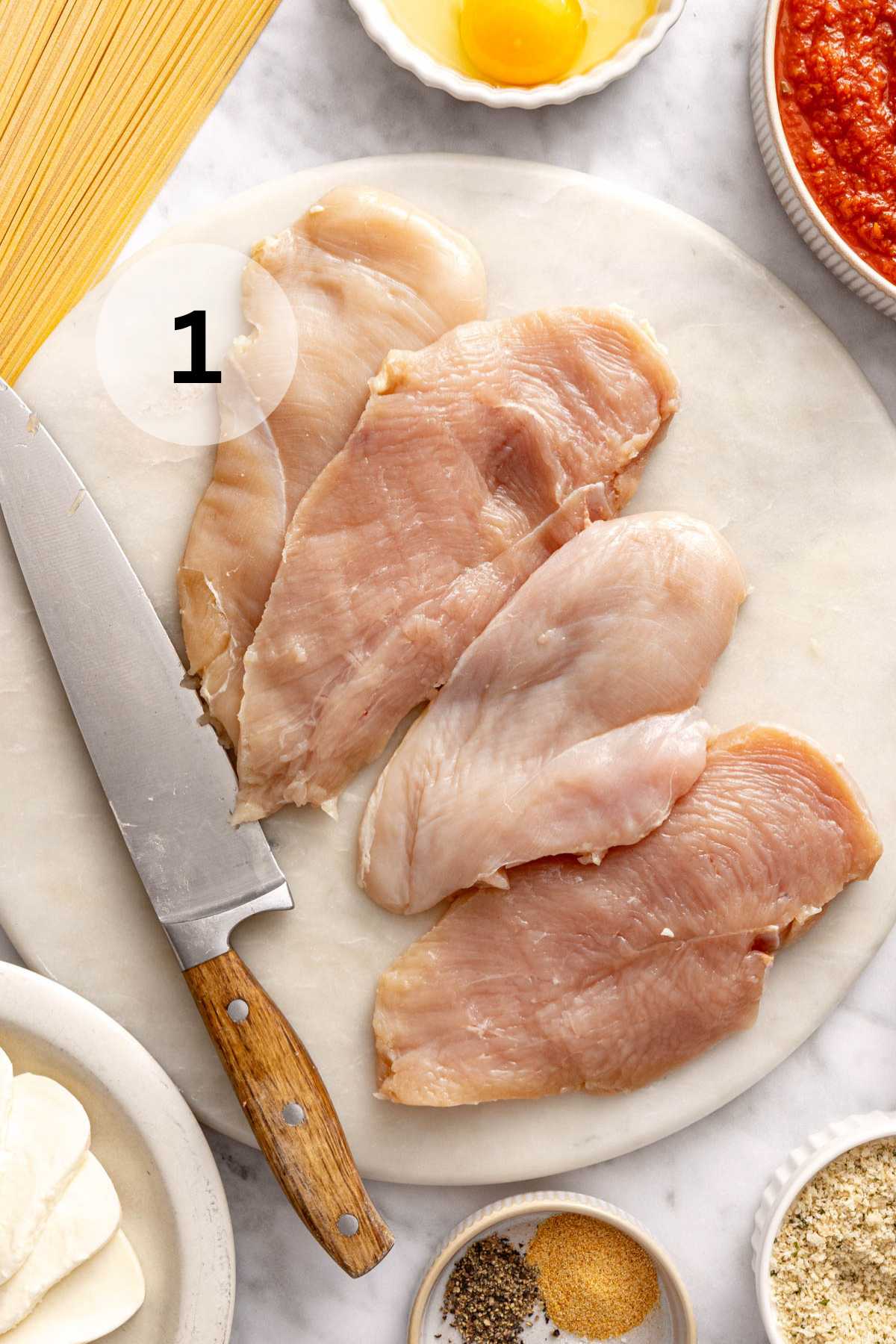 This slices of chicken breast on a cutting board.