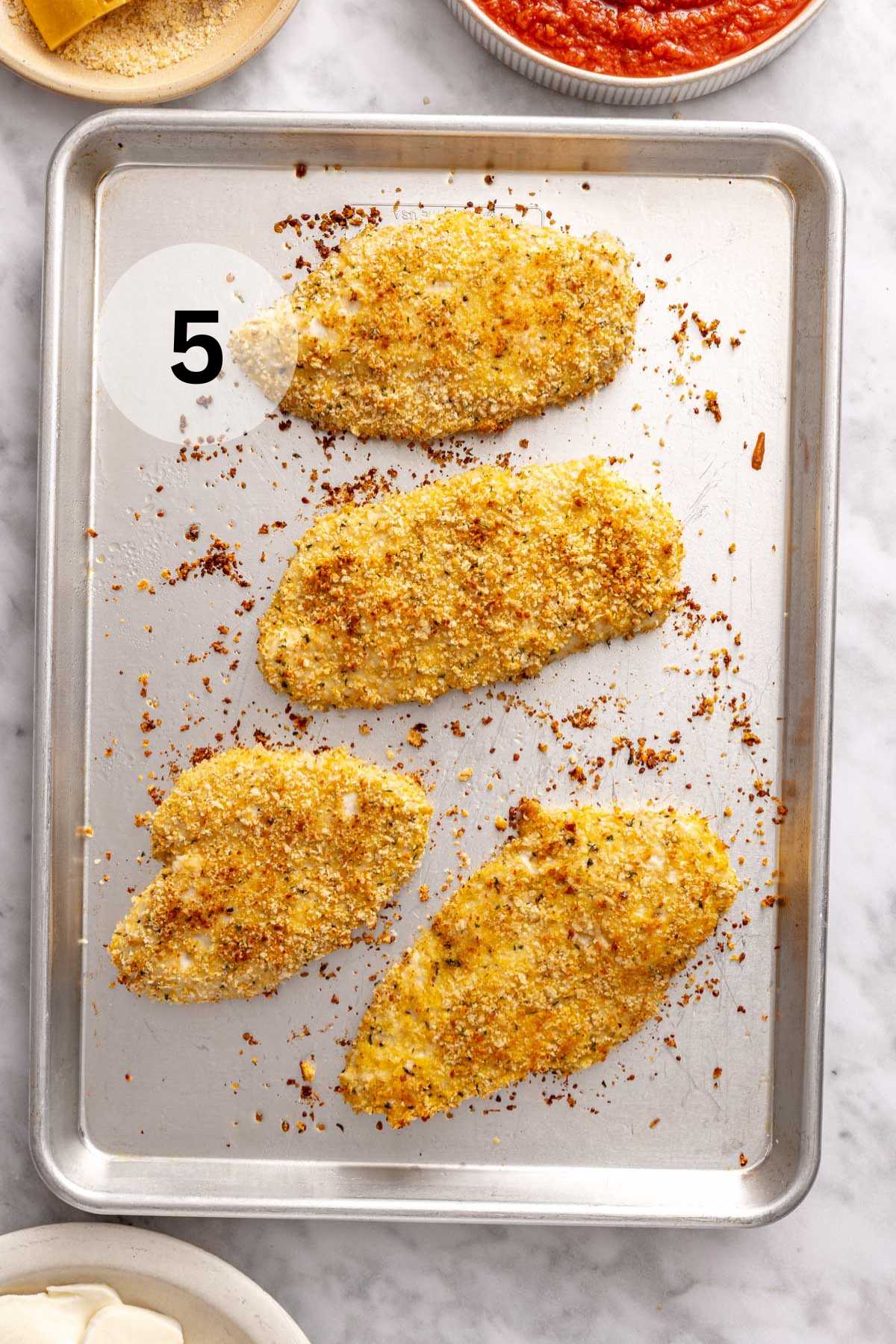 Breaded chicken that is baked on a sheet pan.