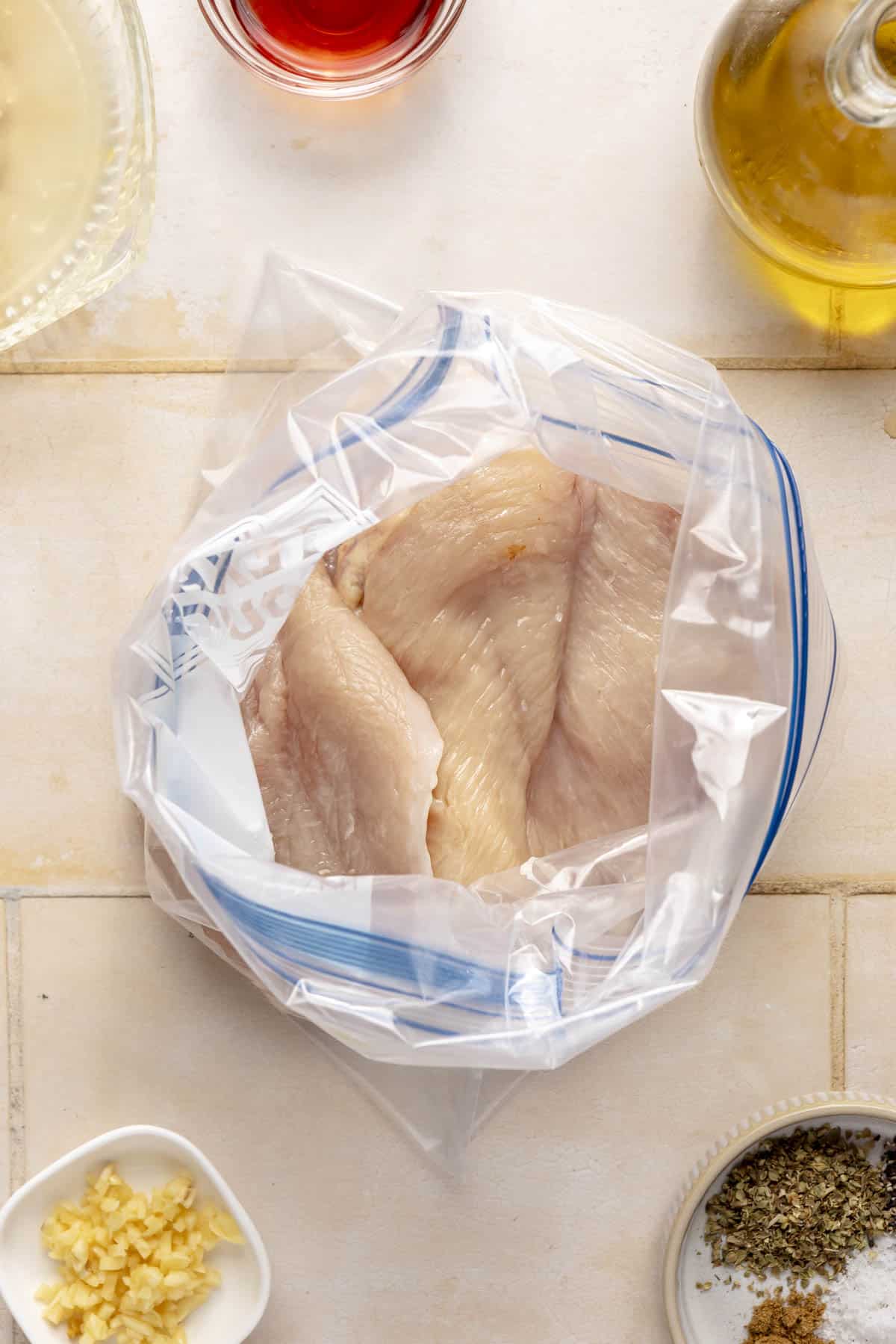 Raw chicken breasts in a large bag.