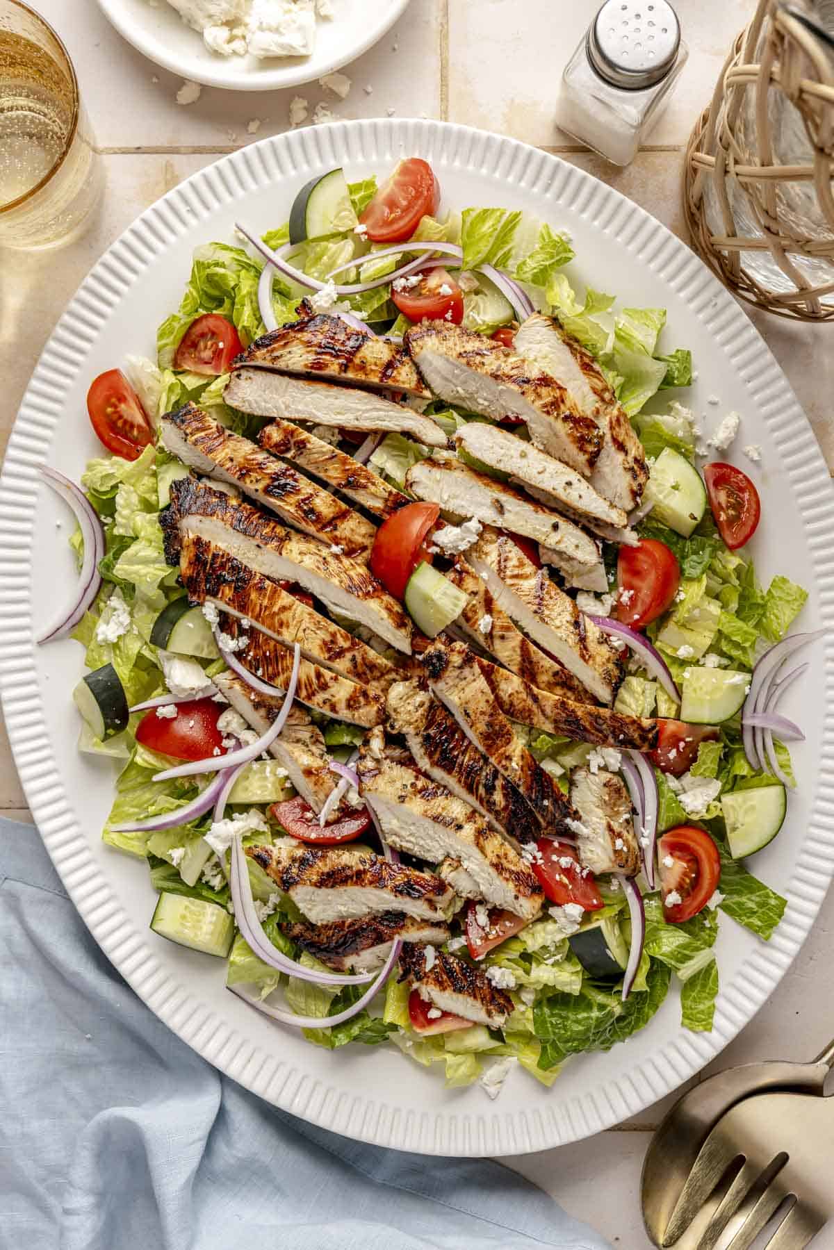 Sliced grilled chicken over a salad.