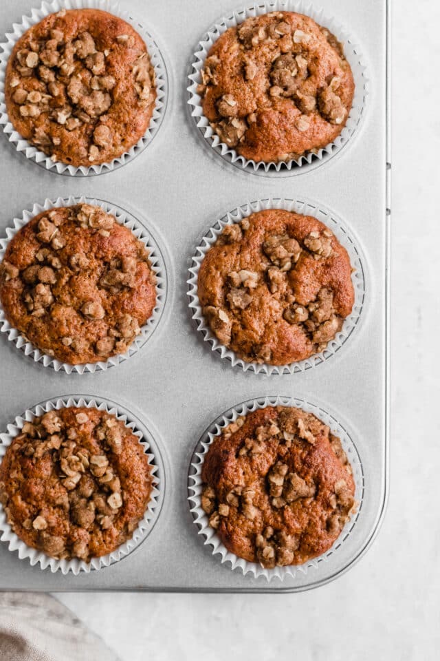 muffins with a cinnamon oat topping in a muffin pan