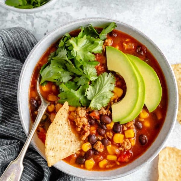 healthy taco soup topped with sliced avocado and fresh cilantro