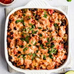 Mexican casserole in a white baking dish and topped with fresh cilantro
