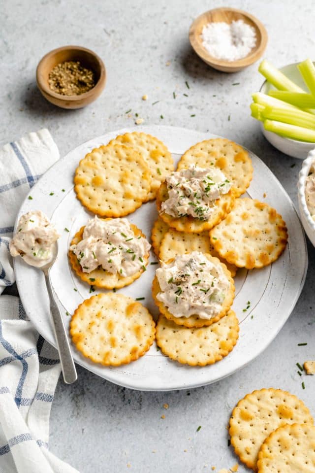 Tuna salad served on crackers on a white plate.