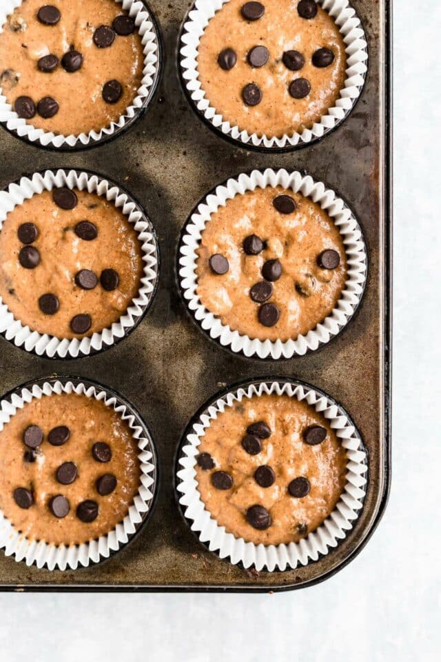 Pumpkin muffin batter in a muffin pan.