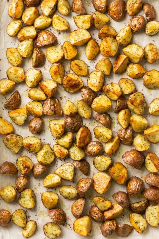 Roasted baby potatoes on a parchment lined sheet pan.