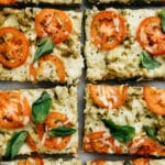 pizza with tomatoes and basil cut into squares