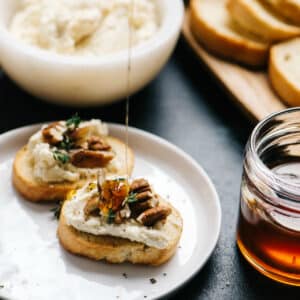 drizzling honey on goat cheese crostini