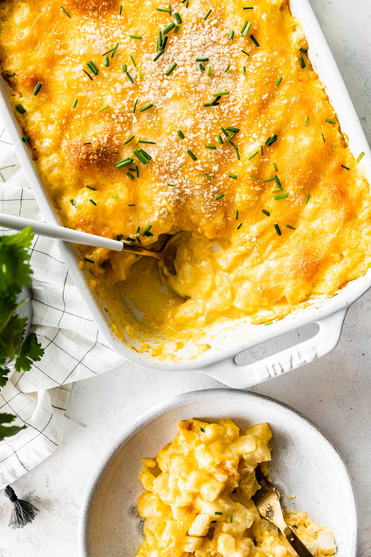 serving cheesy potato casserole out of a baking dish
