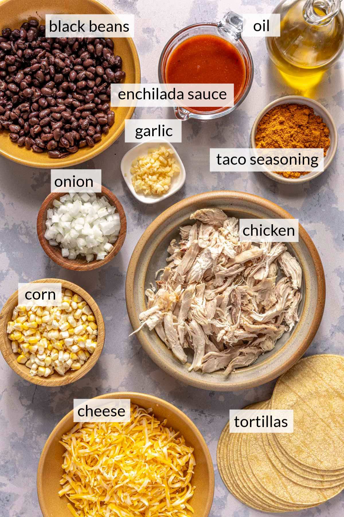 Bowls with shredded chicken, black beans, corn, enchilada sauce and corn.