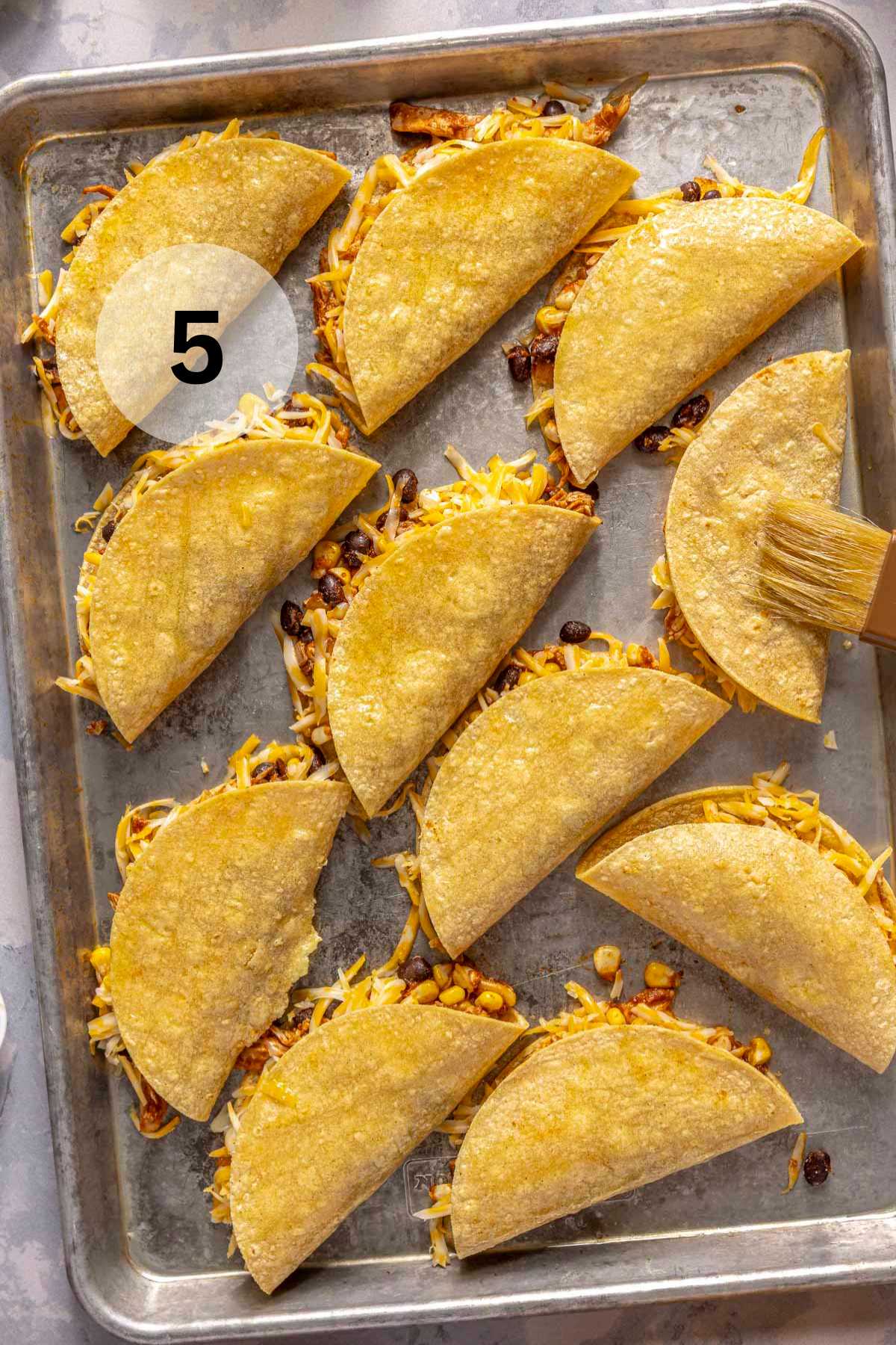 Tacos made with corn tortillas on a sheet pan.