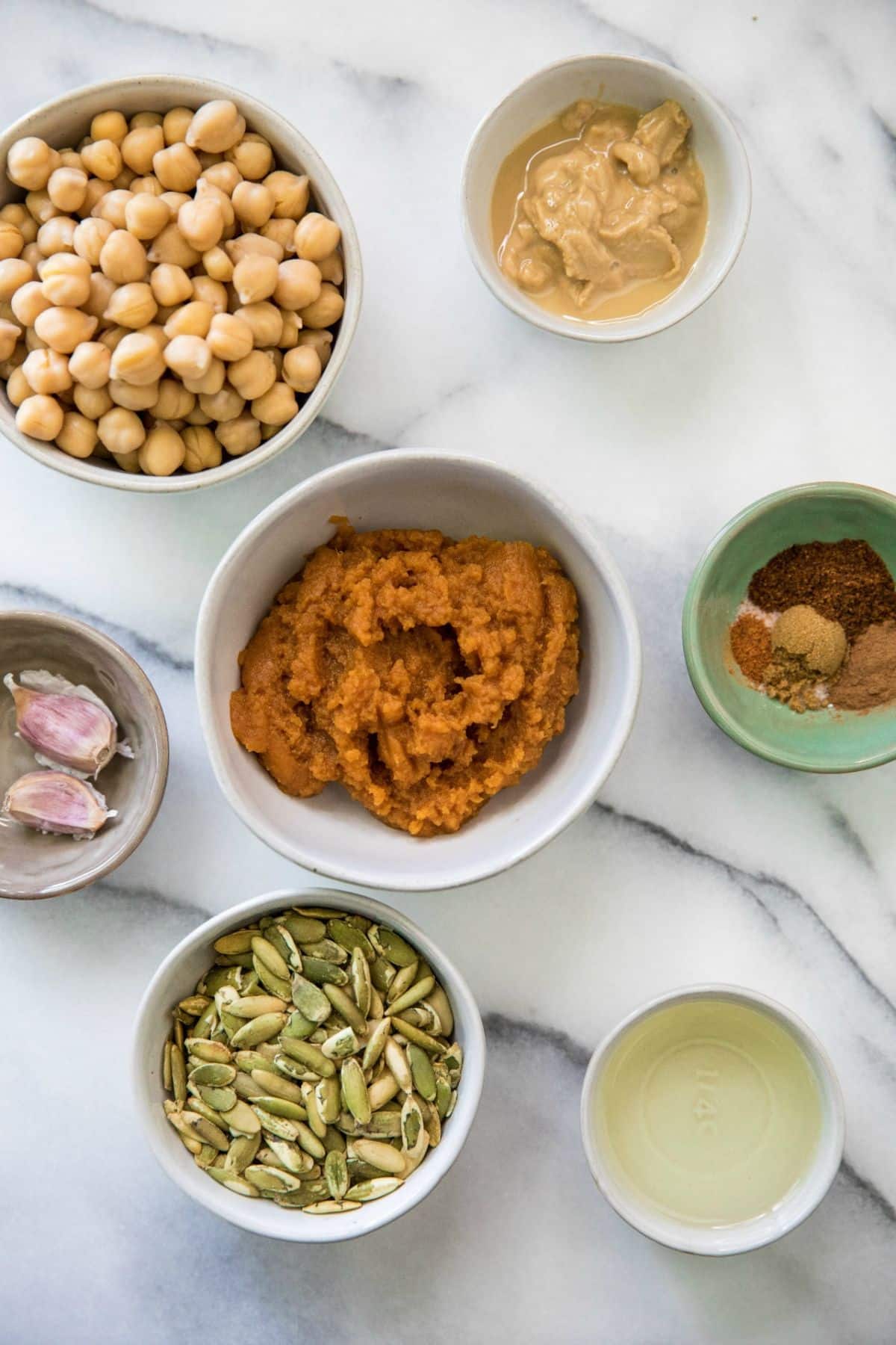 Pumpkin puree, chickpeas, shallots, olive oil and seasonings divided into small bowls.